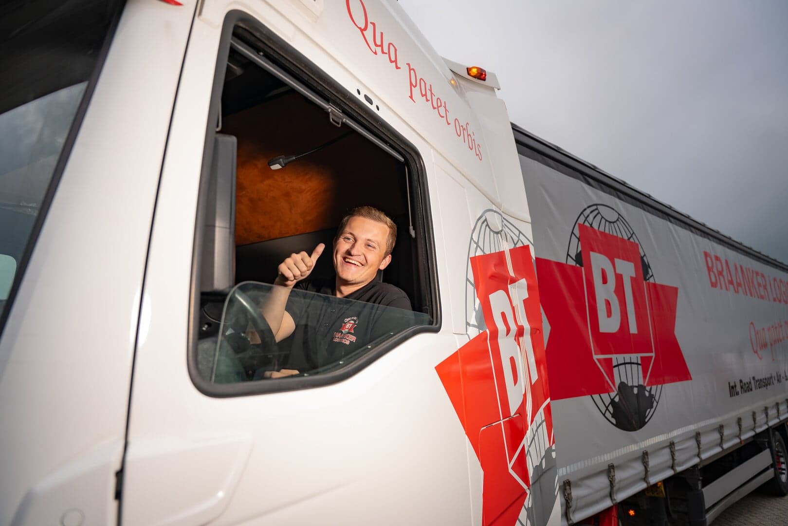 Jonge vrachtwagenchauffeur in de cabine van een vrachtwagen van Braanker Transport.
