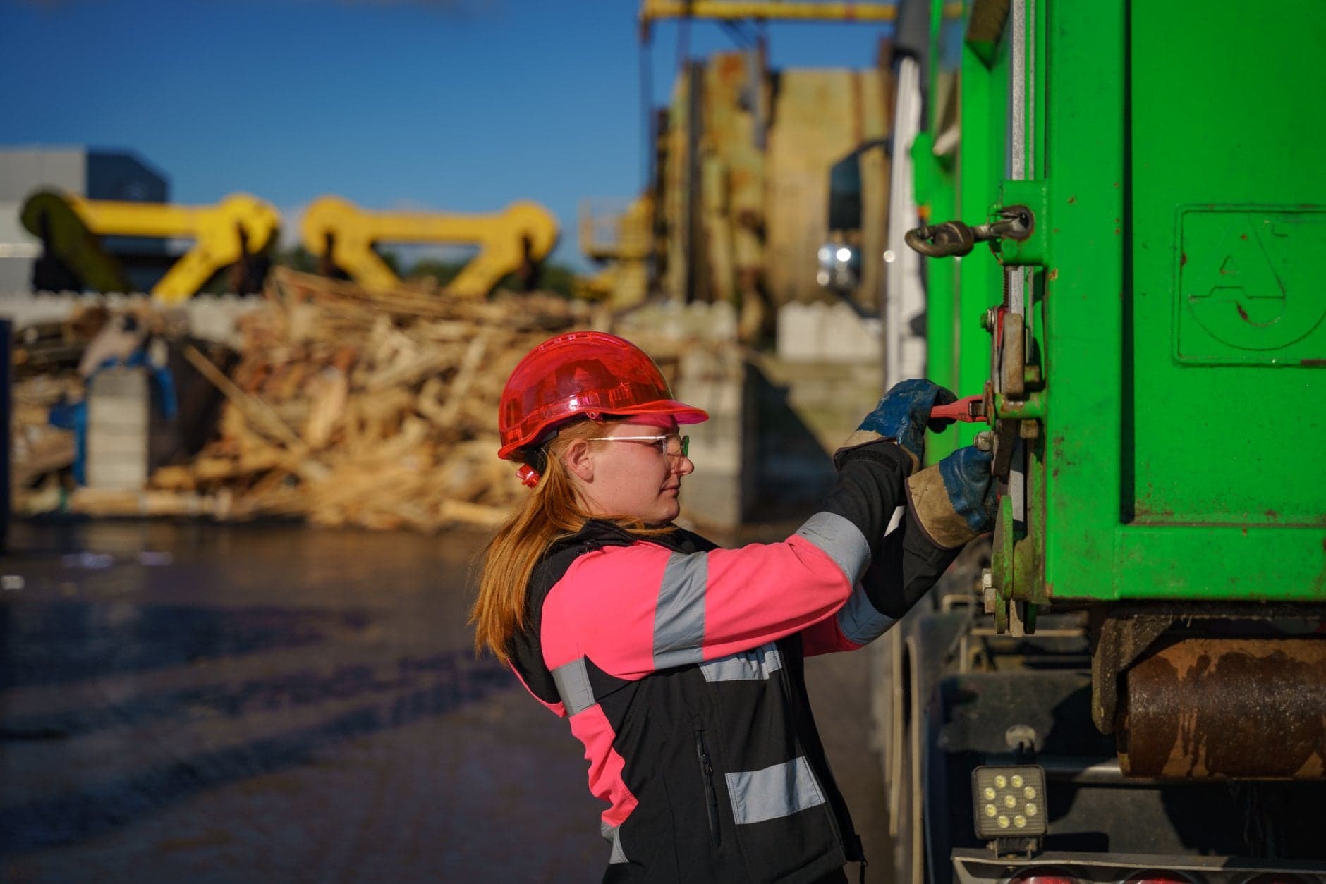 Vrachtwagenchauffeur Paige Timmermans naast een perscontainer