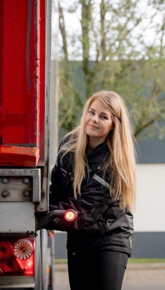 Vrachtwagenchauffeur Sanne Ansmink naast vrachtwagen
