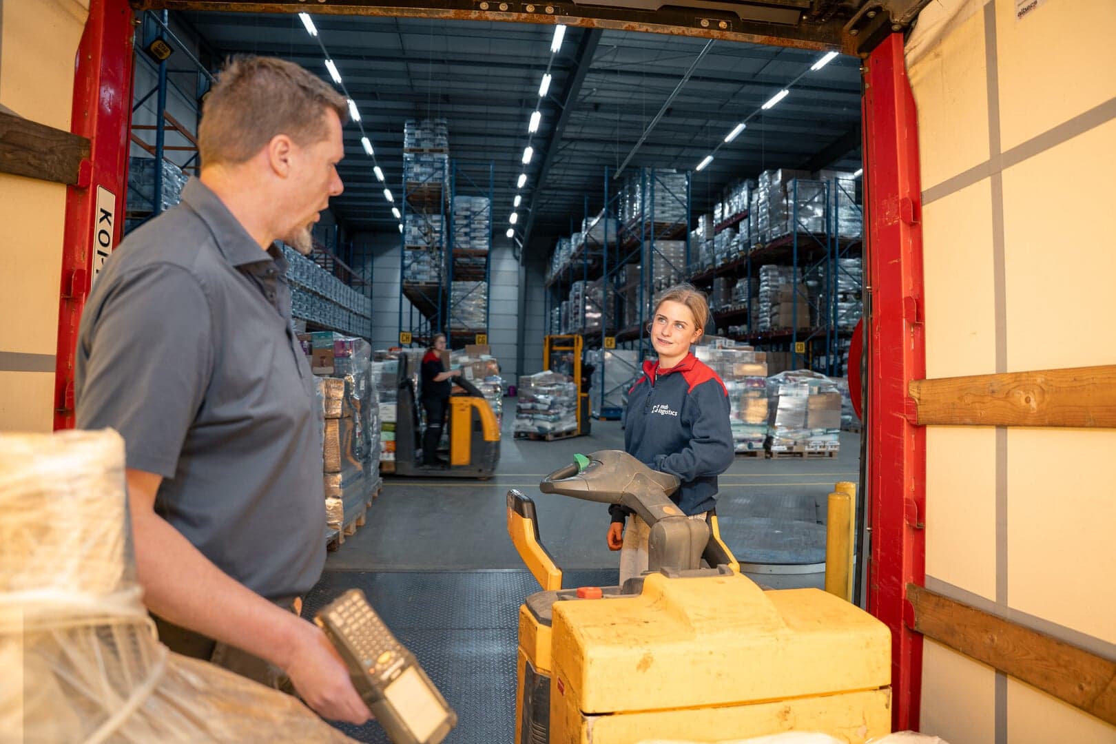levi en haar collega staan in het magazijn en zijn in gesprek
