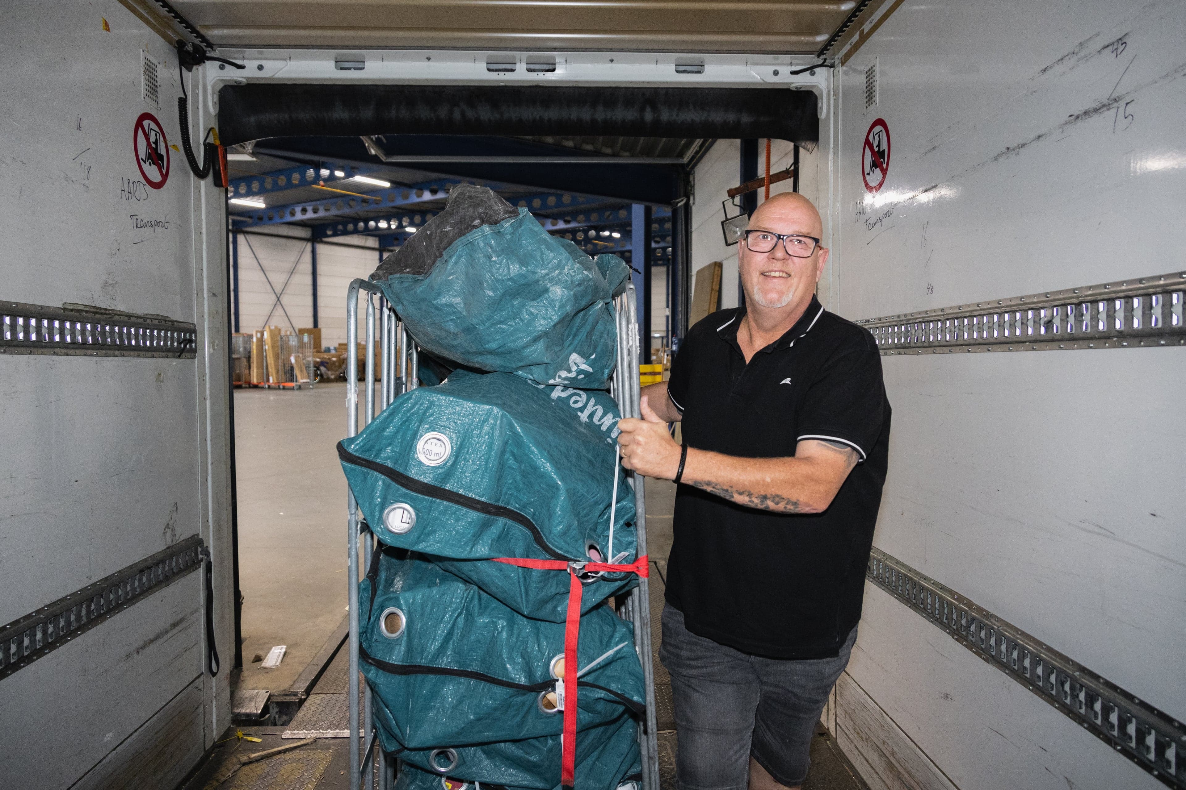 Dove vrachtwagenchauffeur Jan Andrea aan het laden met rolcontainer