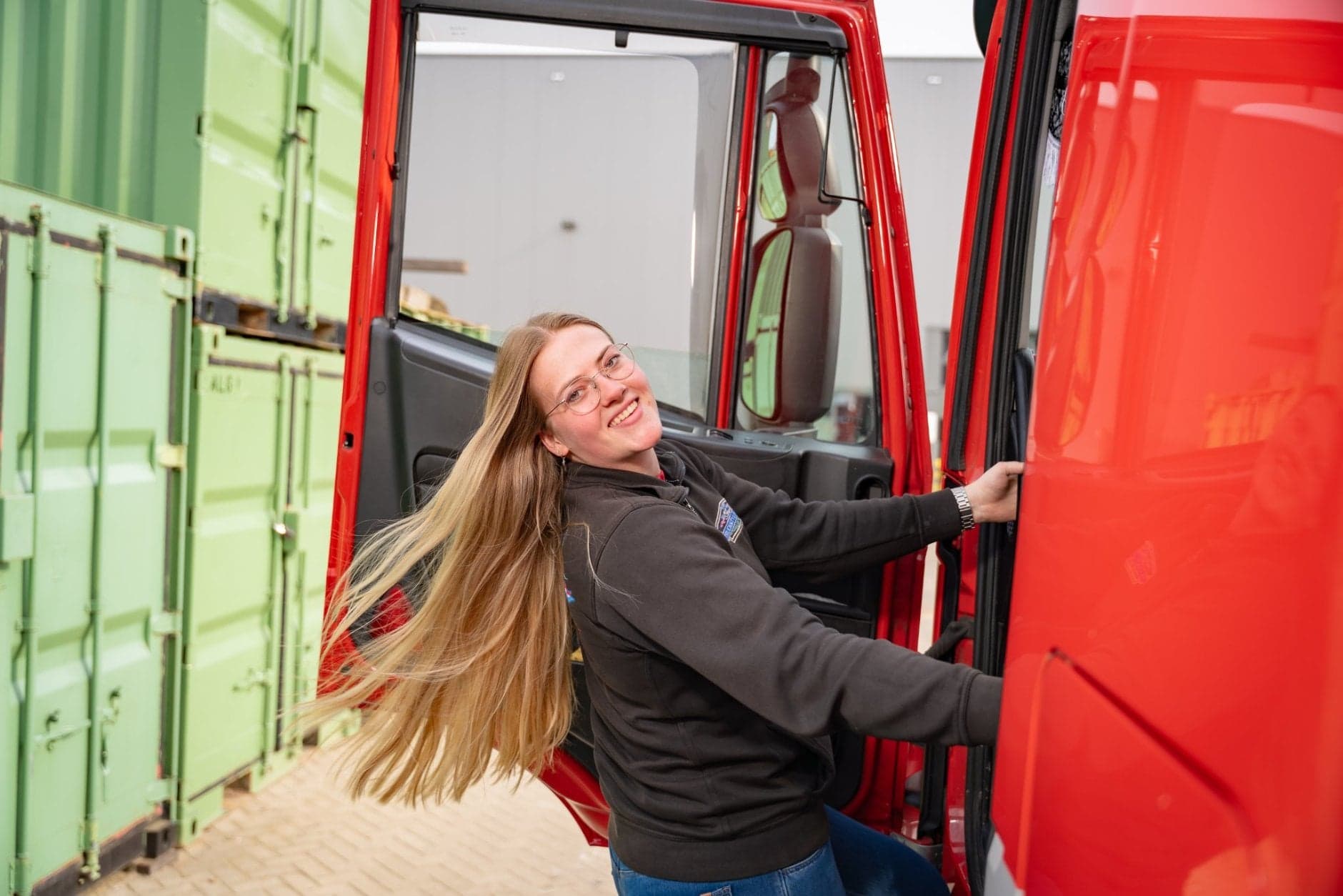 Vrachtwagenchauffeur Chantal hangt uit cabine van vrachtwagen