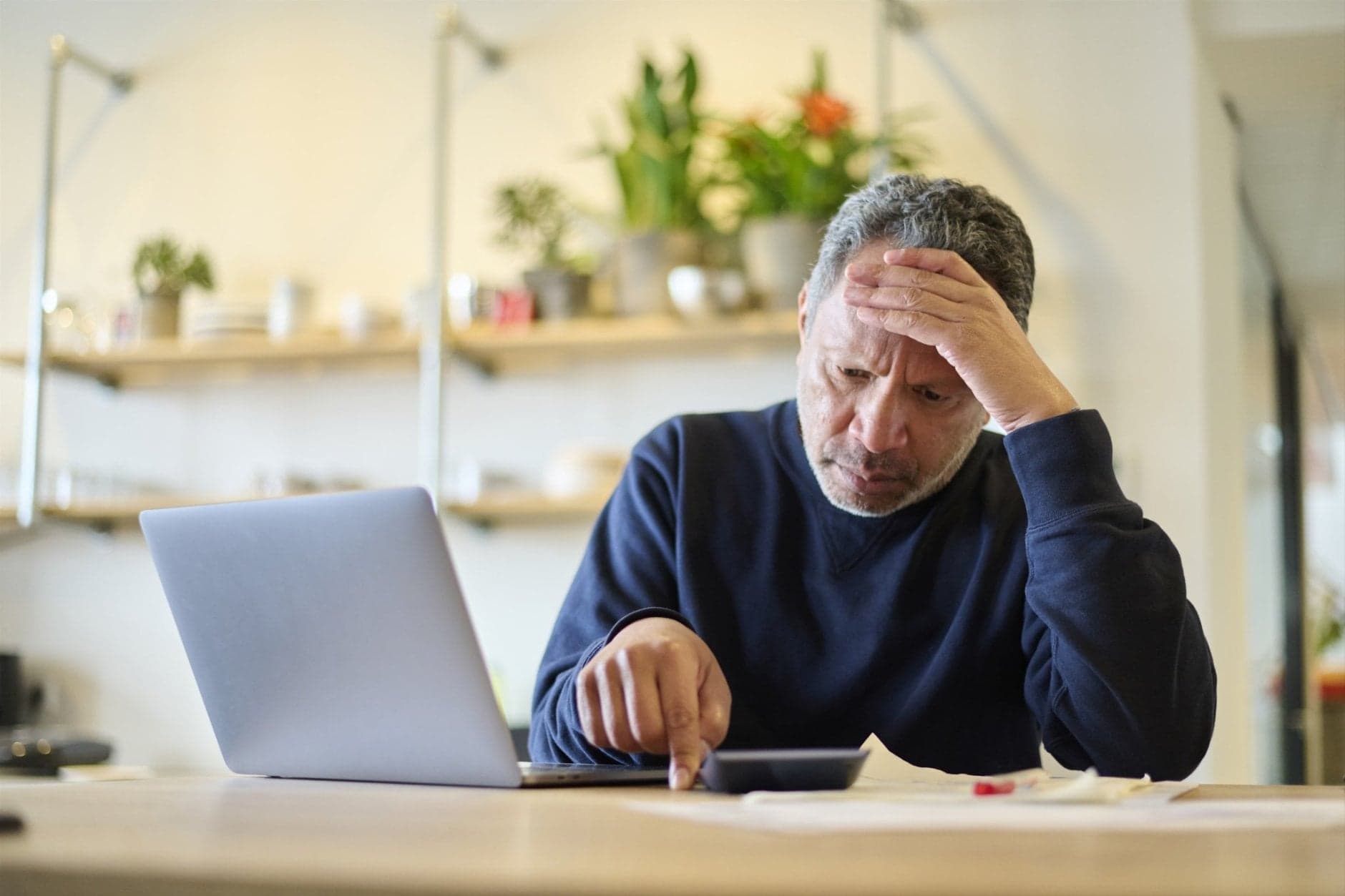 Man kijkt bezorgd naar rekenmachine