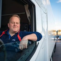 Chauffeur Remco Hoogendoorn in de cabine van een vrachtwagen.