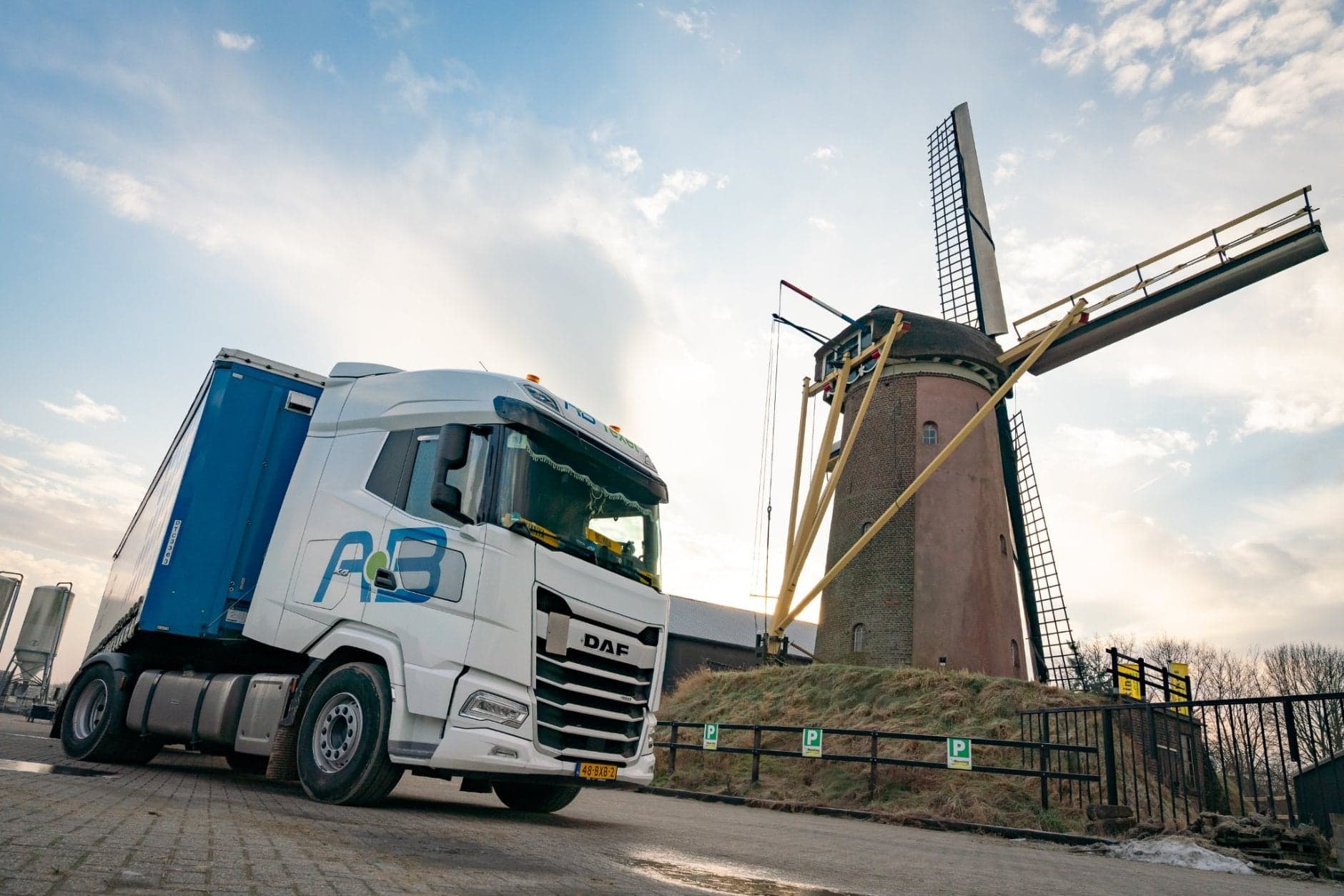 Vrachtwagenchauffeur naast windmolen