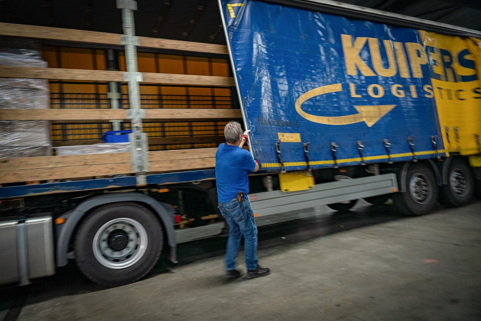 Vrachtwagenchauffeur Arend van der Hoeven sluit het schuifzeil