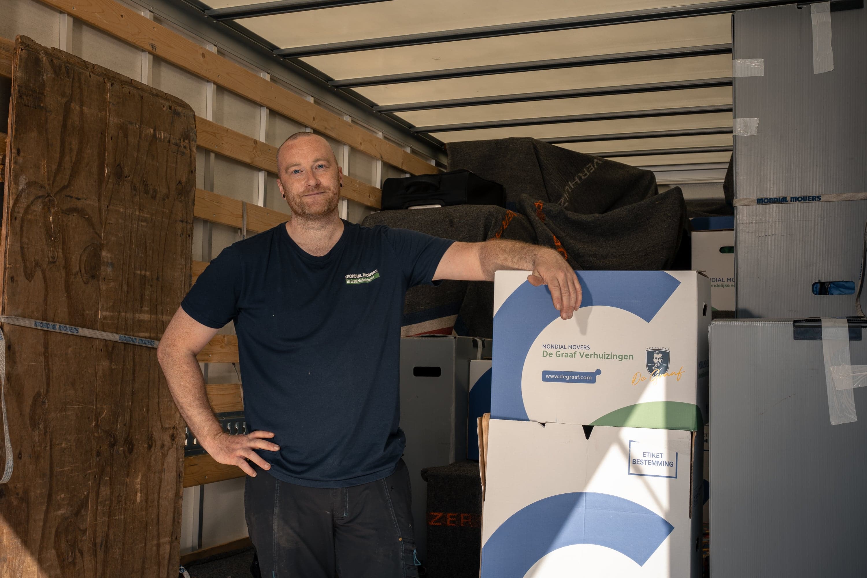 Man in vrachtwagen met verhuisdozen
