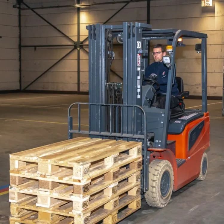 Medewerker Aarts Transport verplaatst pallets met heftruck