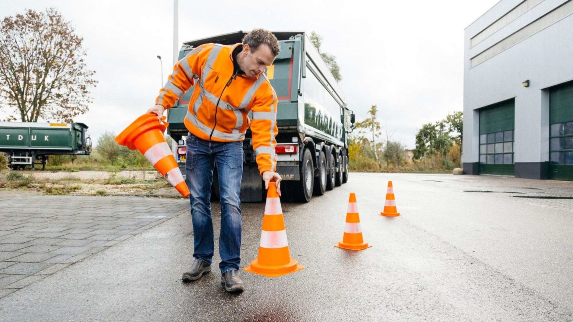 Toolbox STL voor veiligheid, man zet pionnen neer bij kiepauto