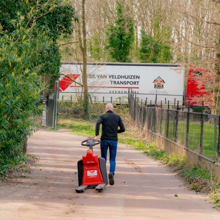 Marco Wassink loopt met pompkar naar zijn vrachtwagen.